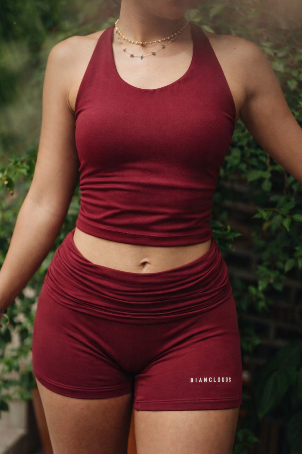 girl wearing a maroon pilates outfit at outdoors.
