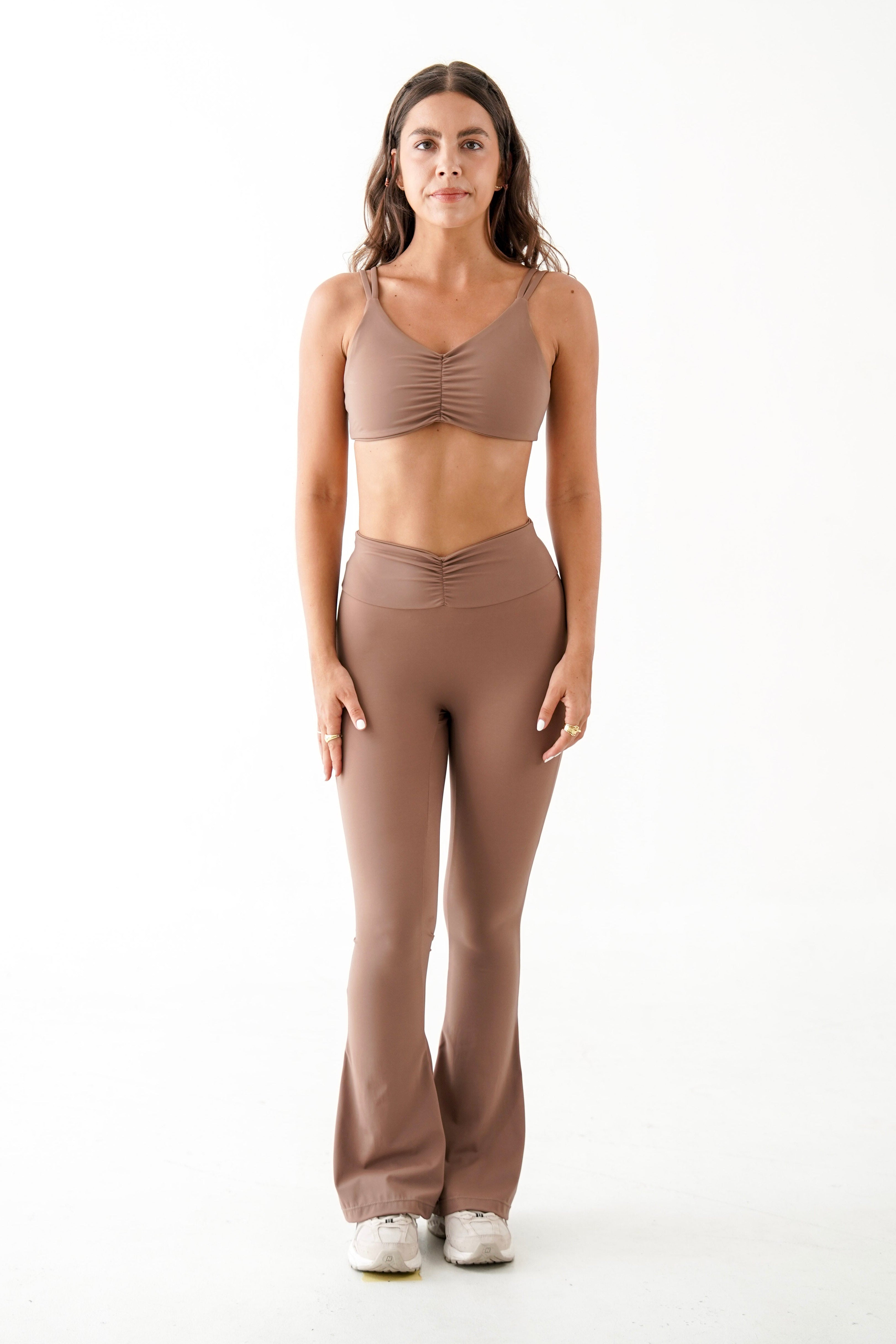 Woman wearing a brown sports bra and leggings